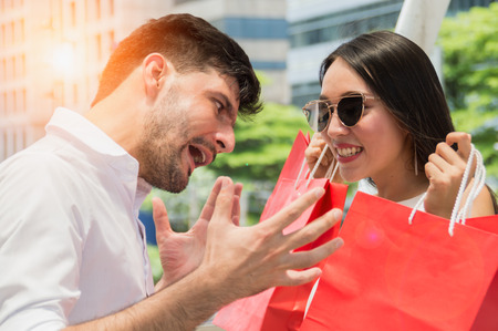 happy young couple with shopping bags walking in mallの写真素材