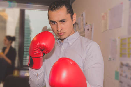 businessmen wearing red boxing gloves throwing a punchの写真素材