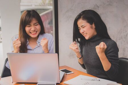 Beautiful girl is working happily on the desk.の写真素材