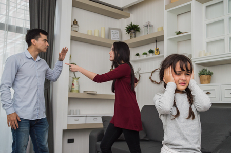 Little girl is crying because her parents quarrel.の写真素材