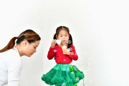 Girls and mom are celebrating Christmas Eve in the house.の写真素材