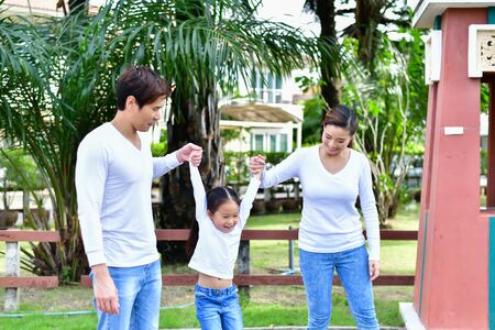 Parents and daughters go for a walk in the park.の写真素材
