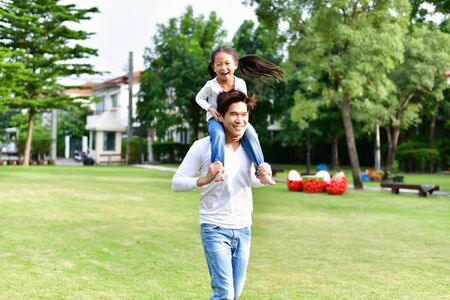Father and her daughters go for a walk in the park.の写真素材