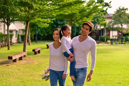 Parents and daughters go for a walk in the park.の写真素材