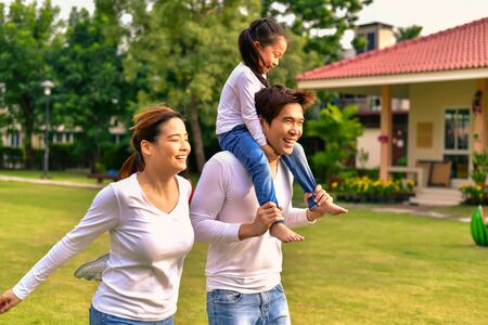 Parents and daughters go for a walk in the park.の写真素材