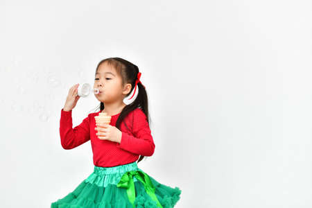 Little girl celebrates Christmas with red Santa dress.