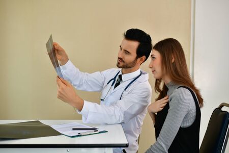Health Concepts. Doctor and patient viewing x-ray film. The doctor and the patient feel relaxed at the check-in time. The doctor encouraged the patient. Inside the hospital are doctor X-ray patient.の写真素材