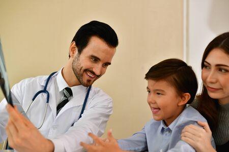 Health Concepts. Doctor and patient viewing x-ray film. The doctor and the patient feel relaxed at the check-in time. The doctor encouraged the patient. Inside the hospital are doctor X-ray patient.の写真素材