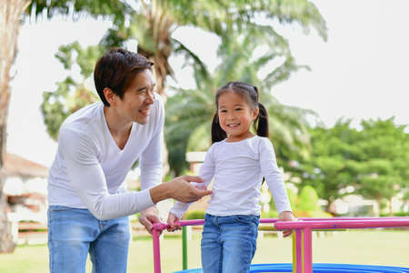 Family Concept. Happy male and female playing with children outside. Family is doing happy activities at Playground.  Parents are playing happily.の写真素材