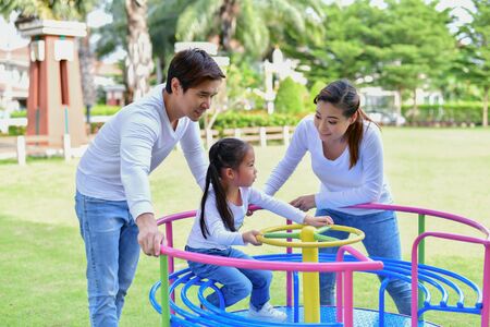 Family Concept. Happy male and female playing with children outside. Family is doing happy activities at Playground.  Parents are playing happily.の写真素材
