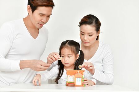 Family Concept. Parents are teaching children to save money. Family is doing happy activities at home.  Parents are playing happily.の写真素材