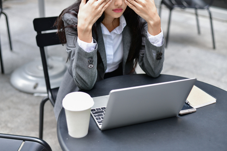 Business Concept. Young businessmen are feeling bad. Young businesswoman is sick. Asian business girl is stressed about her work. Businesswomen are unhappy at work.の写真素材
