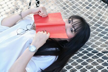 Asian woman reading book in the parkの写真素材