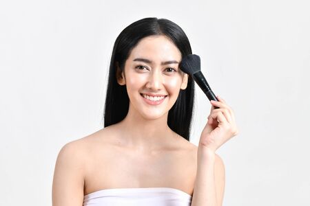 The concept of healthy beautiful woman. Beautiful girl Make up with cosmetics. Beautiful women use cosmetics suitable for the face. Beautiful woman makeup on isolated backgroundの写真素材