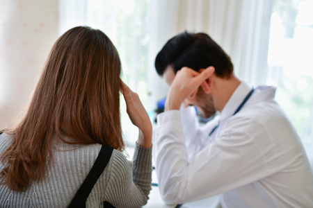 Terrible medical concept. Patients stressful in the doctor's diagnosis. Patients are concerned about medical treatment. The doctor's treatment makes the patient afraid.の写真素材