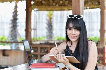 Business Concept.Young Asian businesswoman is working happily.Young businesswoman working in a cafe.Young businesswoman is relaxation in a coffee shop.の写真素材
