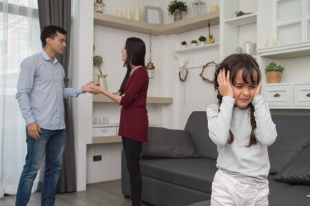 The concept of parental family quarrels, Young Couple Parents are fighting in front of children. The children are very sad to the parents quarrel. Children are crying and headaches.の写真素材