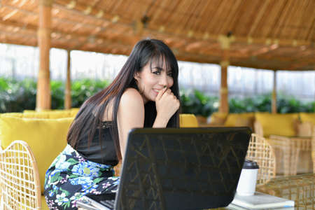 Business Concept.Young Asian businesswoman is working happily.Young businesswoman working in a cafe.Young businesswoman is relaxation in a coffee shop.の写真素材