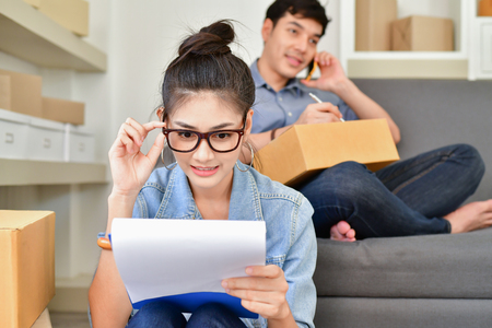 Sme business concept. Young Asian people are packing their packages.Delivery business  Small and Medium Enterprise (SMEs). Young man is working in the house.Young Owner Start up for Business Online.の写真素材