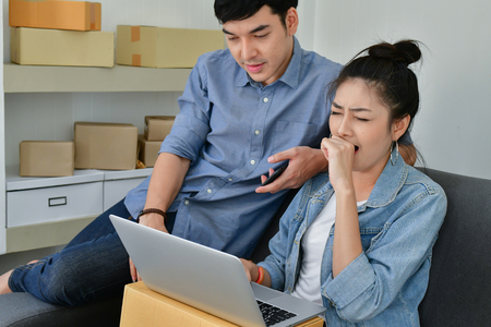 Sme business concept. Young Asian people are packing their packages.Delivery business  Small and Medium Enterprise (SMEs). Young man is working in the house.Young Owner Start up for Business Online.の写真素材
