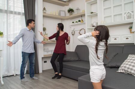 The concept of parental family quarrels, Young Couple Parents are fighting in front of children. The children are very sad to the parents quarrel. Children are crying and headaches.の写真素材