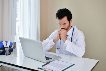 Doctor Concept. Doctors are making serious faces. The doctor is stressed about work. The doctor is feeling a headache at work. The doctor is feeling stressed in treating the patient.の写真素材