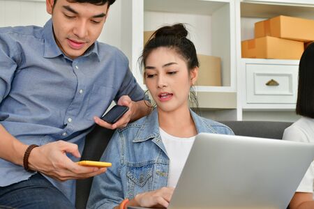 Sme business concept. Young Asian people are packing their packages.Delivery business  Small and Medium Enterprise (SMEs). Young man is working in the house.Young Owner Start up for Business Online.の写真素材
