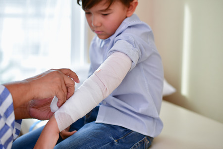 Health Concepts. The doctor is splinting to the patient. The doctor is examining a bone splint. Little children are happy in the healing of the doctor. Close-up image of a doctorの写真素材