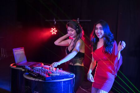 Music Concepts. DJ is rhythm music with Controller and mixer. DJ is playing the song at the party....