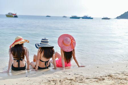 Sexy girl concept in swimsuit. Beautiful woman wearing a swimsuit playing in the beach. Girl in sexy swimsuit poses seductively. Sexy girl seduces a young man on the beach.の写真素材
