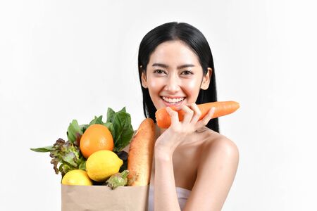 shopping concepts. Beautiful girls are buying fruits and vegetables. Beautiful girl to buy healthy food. Beautiful girl shopping at the bazaar. Asian girl suffocating bags of fruits and vegetablesの写真素材