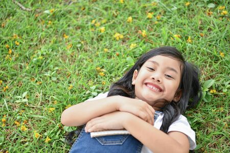 Education Concepts. The girl is reading a book in the garden. Beautiful girl is seriously studying. Beautiful girls are happy learning.の写真素材