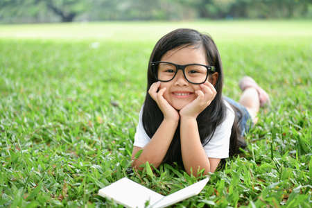Education Concepts. The girl is reading a book in the garden. Beautiful girl is seriously studying. Beautiful girls are happy learning.の写真素材