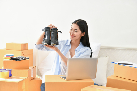 Sme business concept. Young people are packing their packages.Delivery business  Small and Medium Enterprise (SMEs). Young woman is working in the house.Young Owner Start up for Business Online.の写真素材