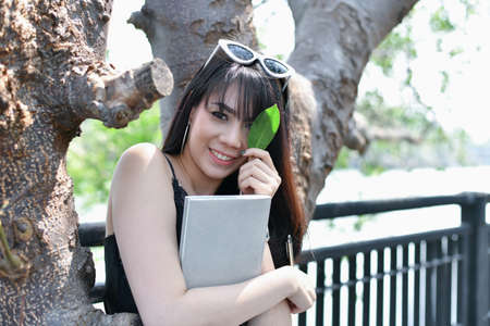 Education Concepts. Asian women reading books in the park. Beautiful women are relaxing in the park....