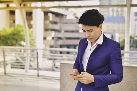 Business Concept Communication, Young businessman is playing mobile.の写真素材