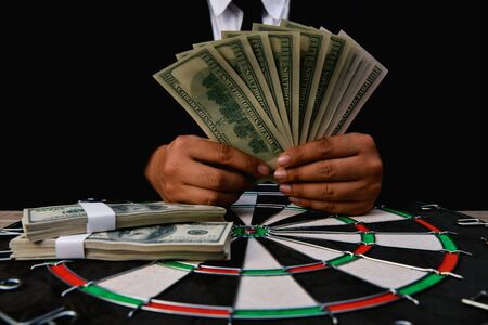 Finance Business Concepts. Lots of money on a black background. Investments are a necessity of business. Businessman looking at a lot of money.の写真素材