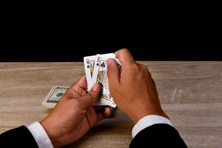 Gambling Concepts. Businessmen are gambling in the casino. Betting is a gamble for investors. Businessmen are playing card games on a black background.の写真素材