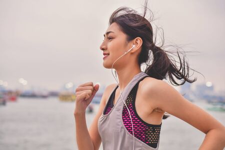 Sports concept. Beautiful girl is exercising on the beach with running. Beautiful girl is happy to exercise. 
Beautiful girls like to exercise by running. People are exercising on the beach.の写真素材