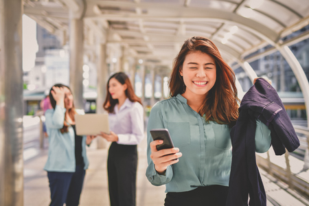 Business Communication Concepts, A young business woman is playing her mobile phone.の写真素材