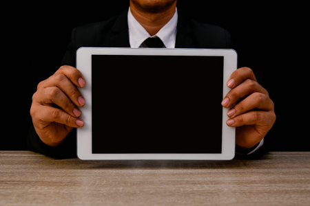 Business concept. Businessman is playing mobile on black background. Business people are browsing the Internet with information technology. Group Businesses interested in Internet knowledge.の写真素材