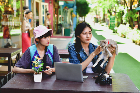 Travel Concept. A tourist girl searching for accommodation on the internet and map. Asian women playing computer.の写真素材