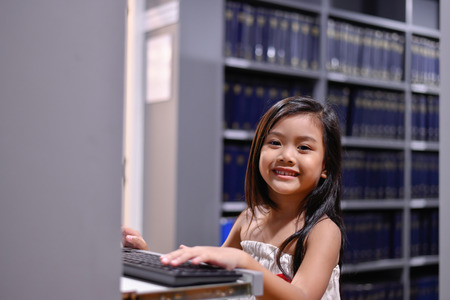Education Concepts. The girl is studying in the library. Beautiful girls are happy learning.の写真素材