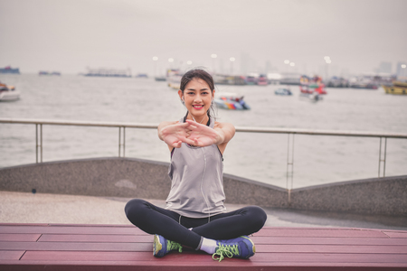 Sports concept. Beautiful girl is exercising on the beach with warm up. Beautiful girl is happy to exercise. 
Beautiful girls like to exercise by warm up. People are exercising on the beach.の写真素材