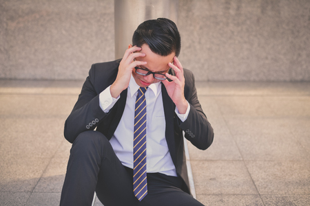 Business Concept Unemployed, Business people are working in the team. Businessmen are saddened by the failures. Businessmen are unemployed. Businessmen are stressed and headaches.の写真素材