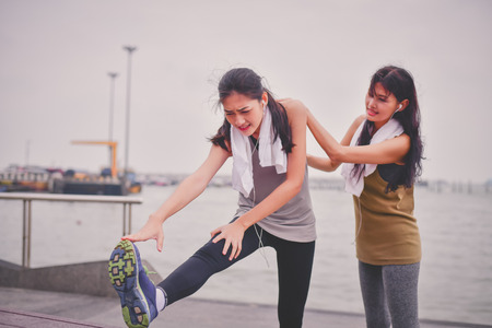 Sports concept. Beautiful girl is exercising on the beach with warm up. Beautiful girl is happy to exercise. Beautiful girls like to exercise by warm up. People are exercising on the beach.の写真素材
