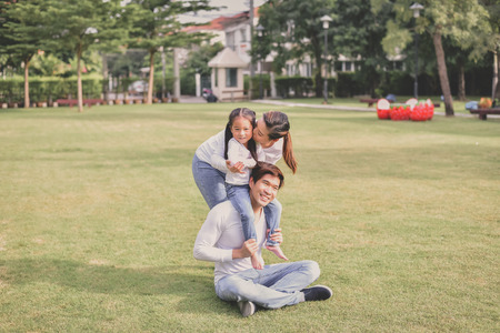 Family Concept. Happy male and female playing with children outside. Family is doing happy activities at Playground.  Parents are playing happily.の写真素材