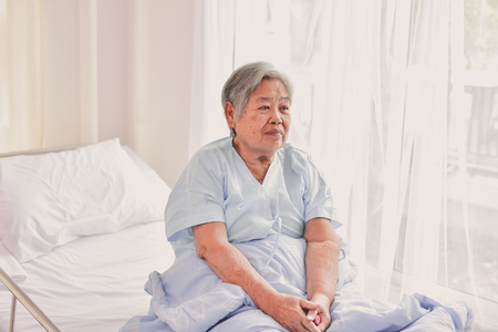Patient Concept. Grandma's in the hospital. Waiting for someone to visit. Grandchildren visit grandma at the hospital. Grandma is happy to meet grandchildren.の写真素材
