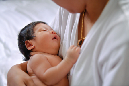 Newborn Concept. Newborn babies are sleeping in a bed. The baby is in the white bedroom.の写真素材