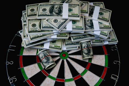 Finance Business Concepts. Businessman is playing darts. Businessmen are aiming for work. Businessman looking at a lot of money.の写真素材